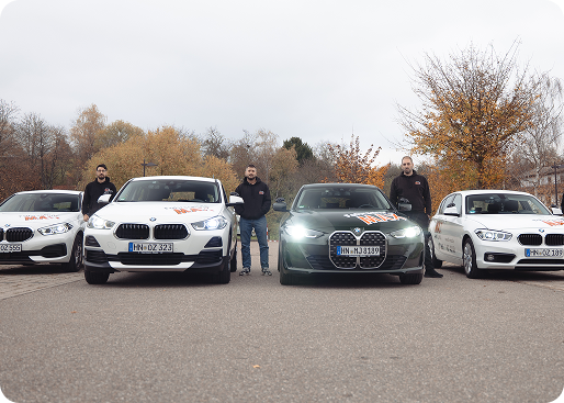 Fahrschulteam vor den Fahrschulautos